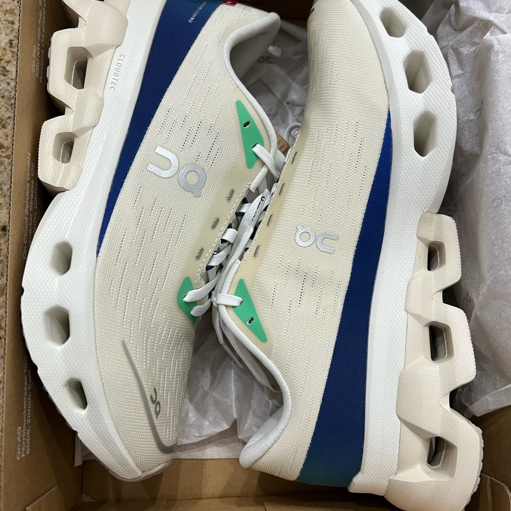 On Running Cream and Blue Athletic Shoes